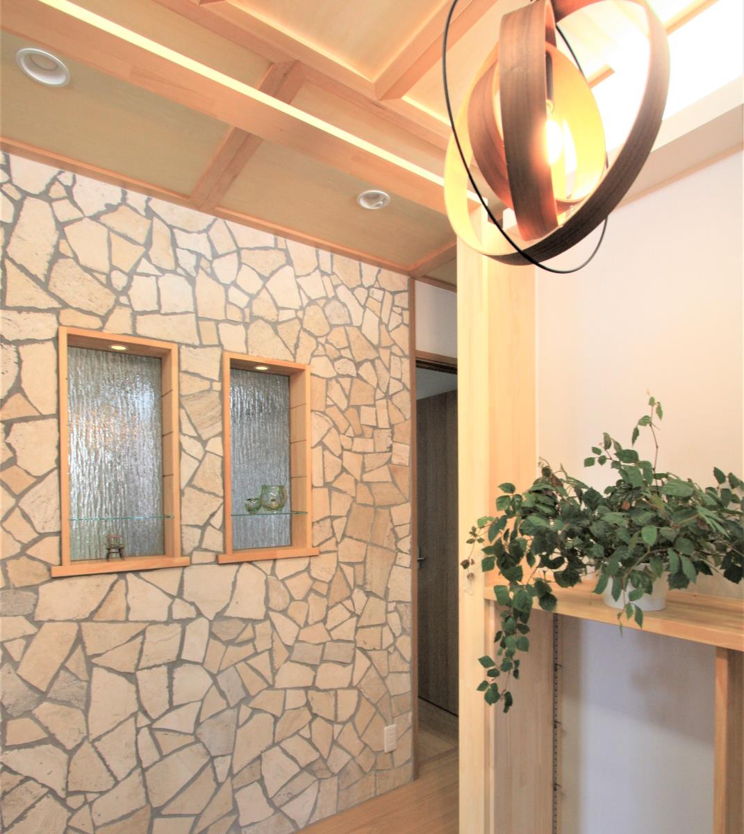 石貼りの壁とすりガラスを使用した玄関ホール